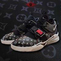 a pair of louis vuitton sneakers on a black background